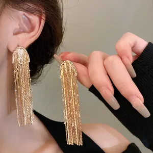 Close-up detail view of elegant gold metal tassel earrings with sparkling rhinestones