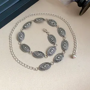 Detailed view of vintage engraved metal waist chain with oval links and lobster clasp.