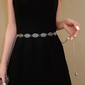 Detailed view of a retro ethnic silver metal waist chain with carved oval links.