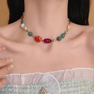 Detailed close-up of a colorful ceramic and glass bead necklace on a female model