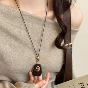 Elegant vintage tiger eye stone resin pendant necklace displayed on a beige sweater outfit