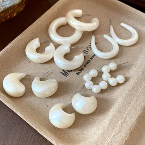 Detailed collection of cream acrylic and faux pearl geometric hoop earring set on tray