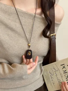 Vintage tiger's eye resin necklace detail shown on model wearing a beige sweater.