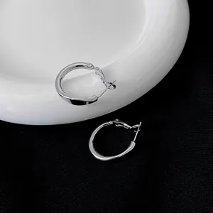 Simple silver geometric hoop earrings with polished finish on black and white background