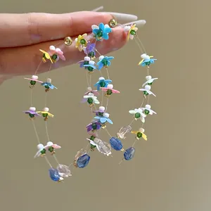 Close-up detail of colorful resin flower hoop earrings with delicate crystal bead accents