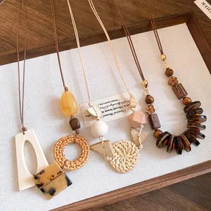Close-up of various bohemian necklaces with rattan weaving and natural wooden beads.