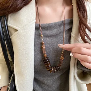 Close-up of bohemian ethnic style necklace with brown wooden beads and discs