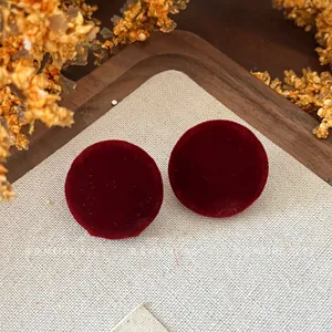 Detailed macro view of vintage burgundy velvet round stud earrings with autumn style