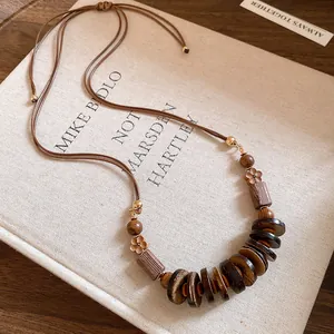 Close-up of bohemian wooden bead necklace with vintage floral and round disc elements