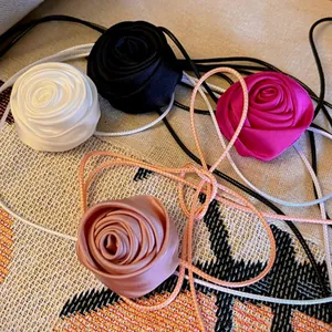 Vue détaillée de colliers ras-de-cou roses en tissu faits main en blanc, noir, rose et champagne.