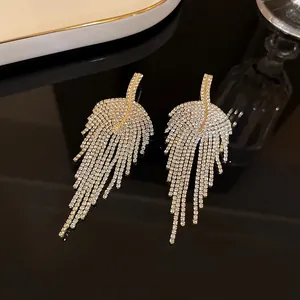 Close-up detail of elegant silver needle earrings with shimmering rhinestone long tassels