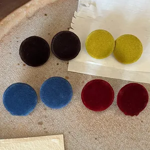 Detail showing colorful retro round fabric stud earrings with soft velvet texture