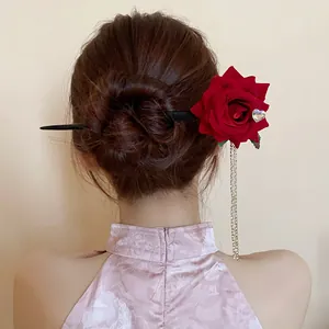 Detail view of a vintage red rose hair stick with long rhinestone tassels worn in a bun