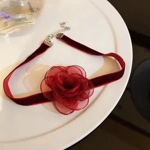 Choker élégant en velours rouge avec un pendentif en forme de rose en tulle rouge.