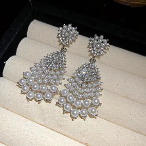 Detail view of vintage court-style drop earrings featuring white pearls and rhinestones