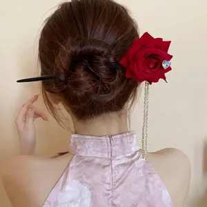 Detailed view of vintage red rose hair stick with crystal heart and long tassels.