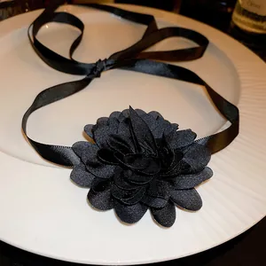 Gros plan détaillé d'une fleur en tissu noir sur un collier choker en ruban de satin
