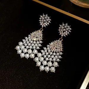 Detail shot of vintage palace style pearl and rhinestone waterdrop tassel earrings.