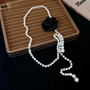 Gros plan détaillé d'un tour de cou en perles vintage avec une rose en tissu noir chic