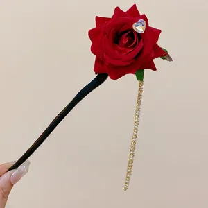Close-up of vintage red fabric rose hair stick with long crystal tassel detail