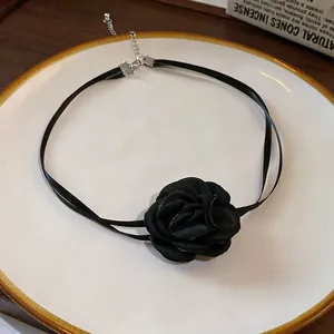 Vue détaillée d'un ras du cou rétro à rose noire française avec rubans en soie sur une assiette