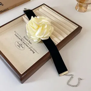 Détail d'un collier ras de cou en velours vintage avec rose en satin crème