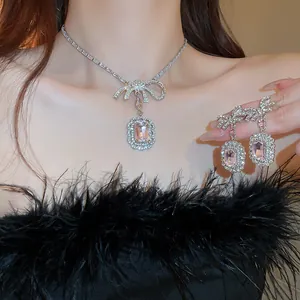 Close-up of elegant pink gemstone jewelry set with rhinestone bow necklace and earrings