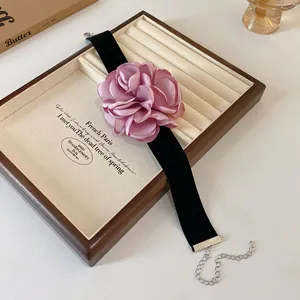 Détail de près du choker en velours vintage avec une grande rose en soie faite main