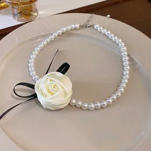Détail d'un choker en perles vintage français avec rose en satin et ruban noir