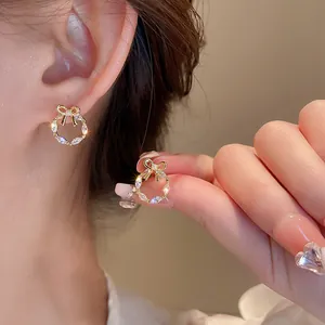 Gros plan de boucles d'oreilles couronne dorées avec zircon marquise et perles