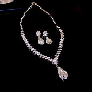 Detailed view of luxury pear-cut crystal necklace and earrings set on black surface.