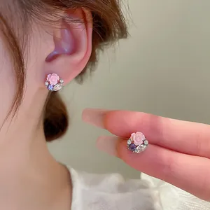 Détail de boucles d'oreilles rose délicate avec zircon étincelant et perles fines