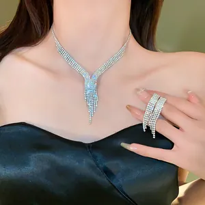 Detailed close-up of a luxurious rhinestone tassel necklace and earring set on a model