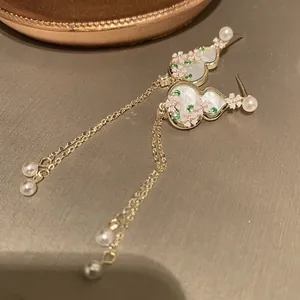 Detail shot of new Chinese gourd earrings with enamel flower patterns and pearl tassels