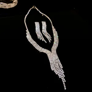 Detail of elegant silver-colored tassel necklace and earrings set with rhinestones