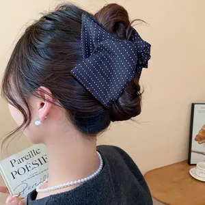 Vue détaillée d'une pince à cheveux à pois noirs coréenne portée dans un chignon.