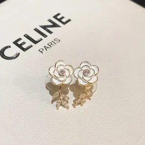 Élégantes boucles d'oreilles camélia blanc avec plaquage or et détails en zircon