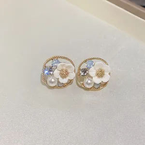 Gros plan détaillé de boucles d'oreilles florales avec perles blanches et cristaux brillants