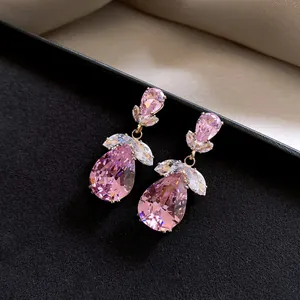 Macro detail of elegant pink teardrop zircon earrings with vintage floral design