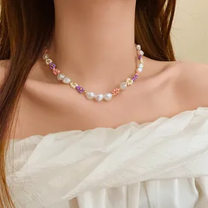 Macro view of a colorful beaded flower and pearl choker necklace on a female model