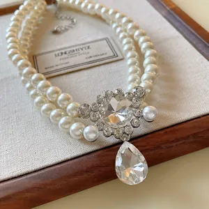 Close-up of French vintage double-layer pearl necklace with sparkling teardrop crystal.