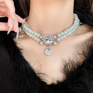 Close-up of elegant double-layered pearl choker with sparkling water drop pendant