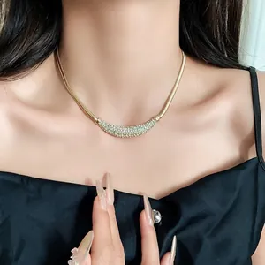 Elegant gold-tone necklace with a pavé crystal crescent pendant worn by a model.