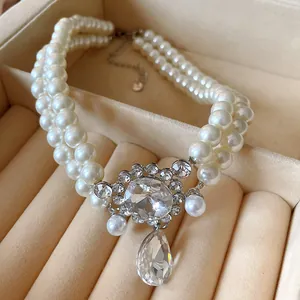 Close-up of French-style double-layered pearl necklace with rhinestone teardrop pendant