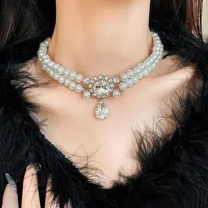 Close-up of double-layered faux pearl necklace with rhinestone water-drop pendant.