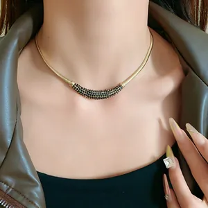 Close-up of elegant gold crescent necklace with black pave crystals on female model