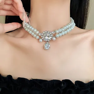 Close-up of elegant double-layer faux pearl choker with rhinestone teardrop pendant.
