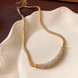 Detailed view of gold necklace with crescent pendant pave-set with sparkling rhinestones