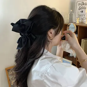 Detailweergave van een Franse vintage haarclip met een grote zwarte satijnen strik