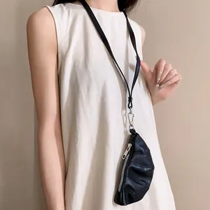 Primer plano de un monedero croissant negro usado como accesorio de collar elegante